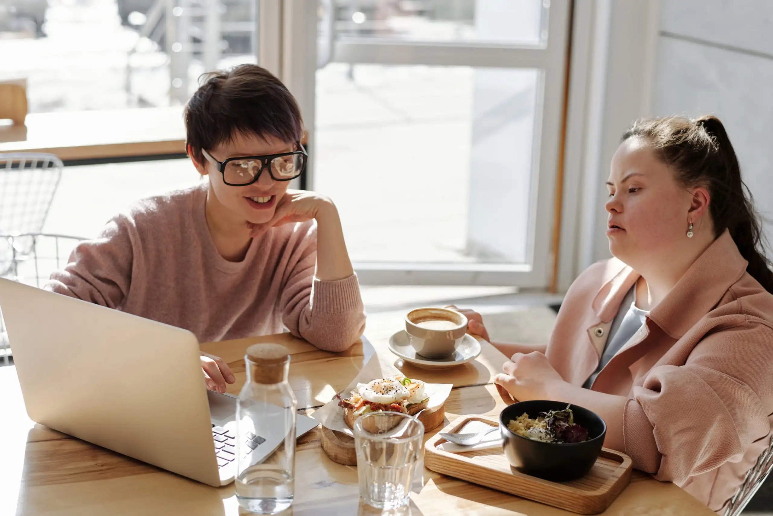 Two friends talking over coffee at a cafe table