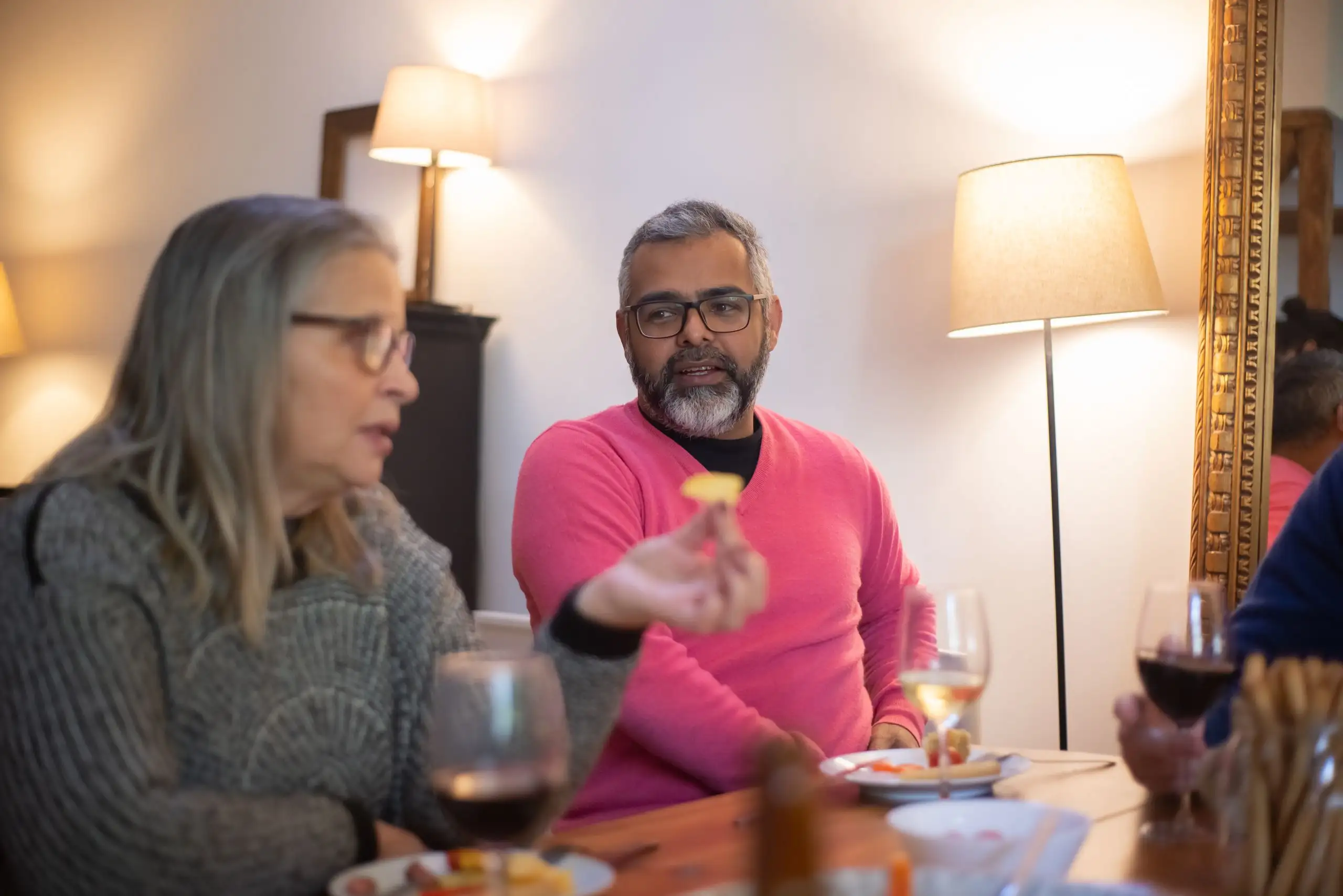 Two adults talking over drinks at a table